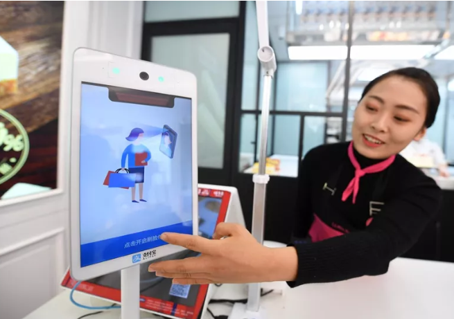 服務員在演示支付寶蜻蜓刷臉支付產品.png